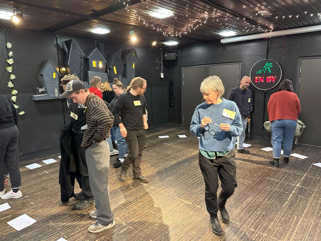 A group walking around a studio space during a workshop.